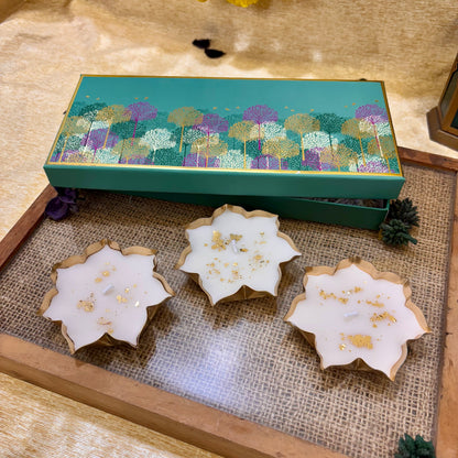 Kamal vanilla-scented lotus candle set of three white candles with gold detailing in a teal gift box by ATLA.
ATLA Kamal lotus candle gift set, a decorative luxury gift for Diwali celebrations, festive hosting and corporate gifting.